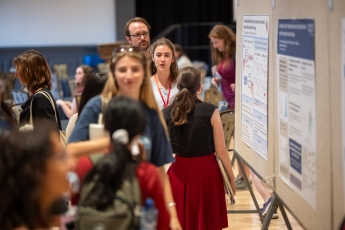 Person speaking in front of academic poster